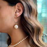 model wearing 18k gold textured hoop earrings featuring a coin pearl