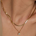 18k gold layered necklace featuring a diamond, designed to be waterproof and hypoallergenic for everyday wear.