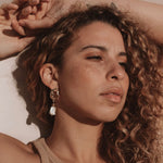 Gold abstract earrings featuring a rectangular pearl