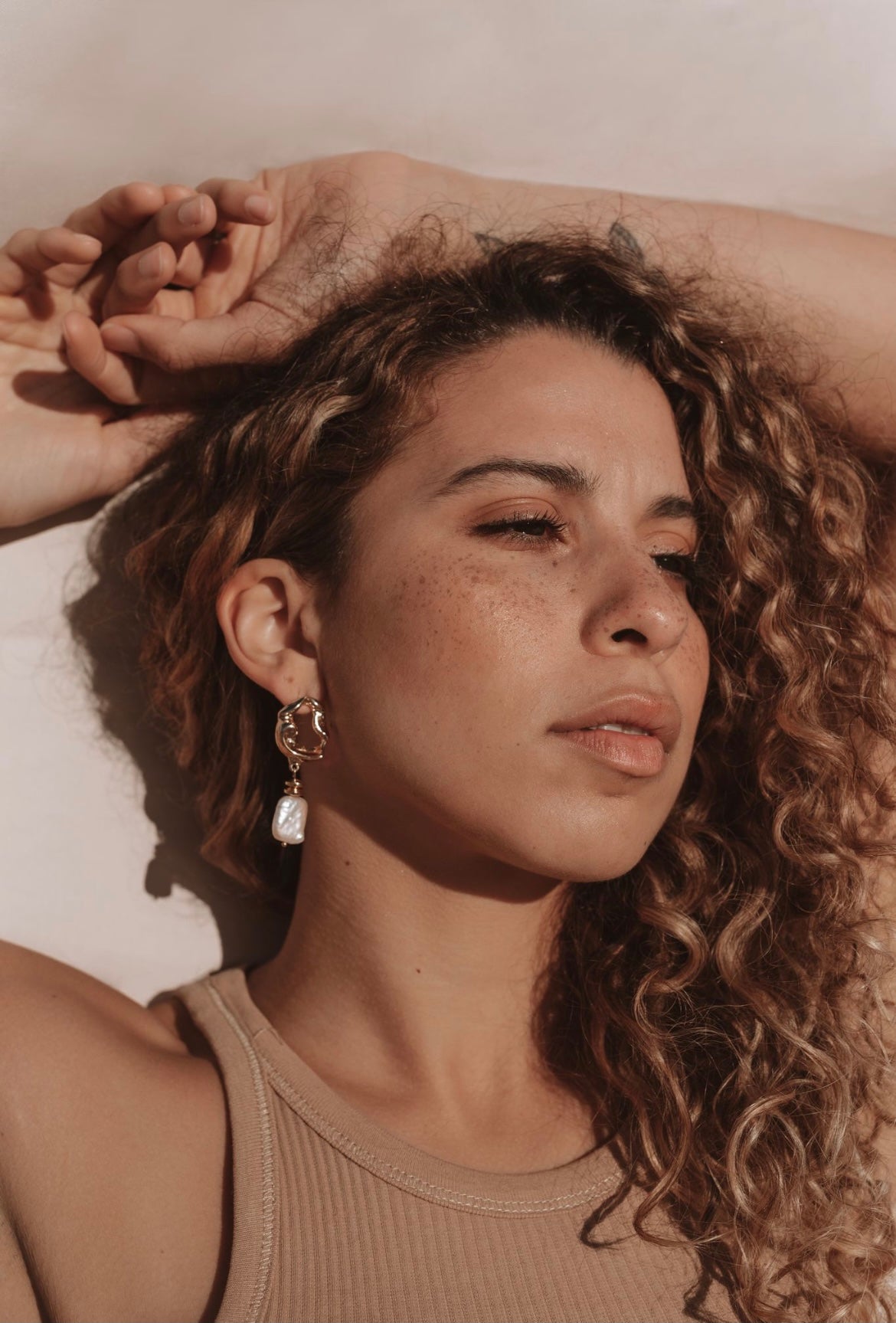 Gold abstract earrings featuring a rectangular pearl