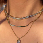 model wearing 18k gold layered necklace featuring a diamond, designed to be waterproof and hypoallergenic for everyday wear.