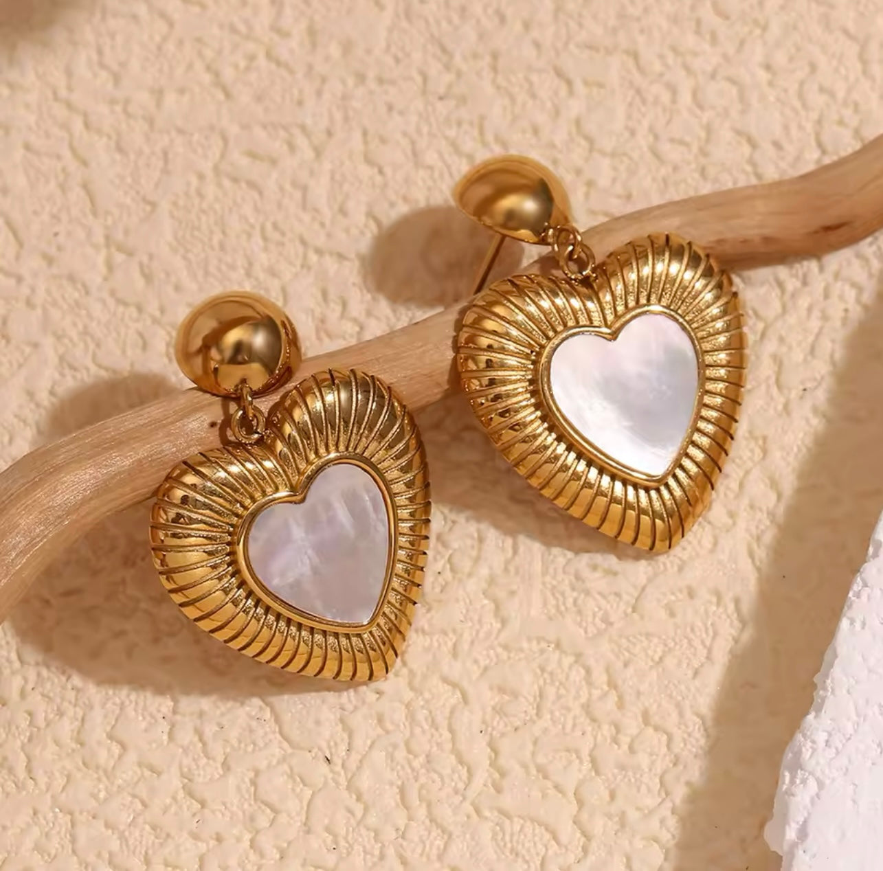 18k gold heart-shaped earrings featuring a mother of pearl inner layer, designed to be hypoallergenic and waterproof