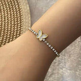 Model wearing 18k gold tennis bracelet featuring a butterfly and flower design with mother of pearl and high-quality cubic zirconia, crafted to be tarnish-resistant for enduring elegance