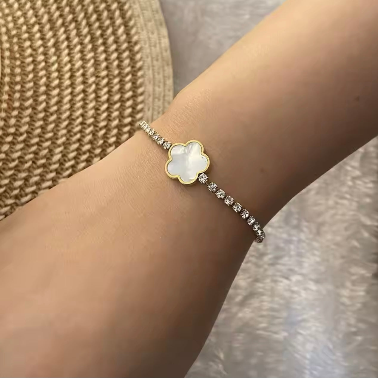 Model wearing 18k gold tennis bracelet featuring a flower design with mother of pearl and high-quality cubic zirconia, crafted to be tarnish-resistant for enduring elegance