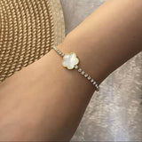 Model wearing 18k gold tennis bracelet featuring a flower design with mother of pearl and high-quality cubic zirconia, crafted to be tarnish-resistant for enduring elegance