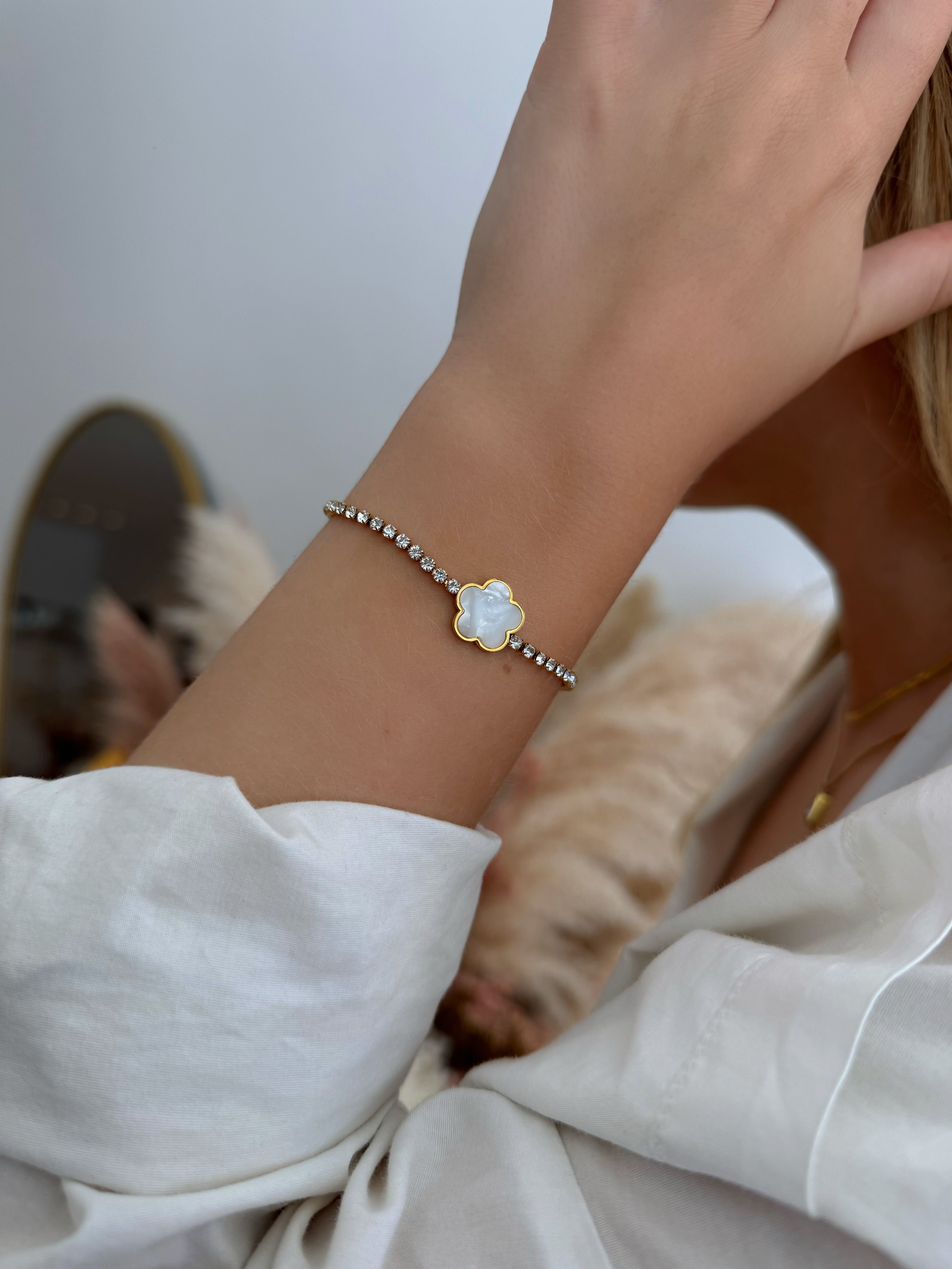 Model wearing 18k gold tennis bracelet featuring a flower design with mother of pearl and high-quality cubic zirconia, crafted to be tarnish-resistant for enduring elegance